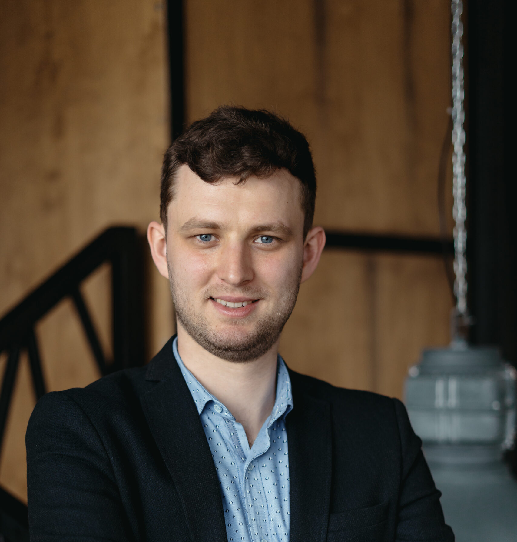 Executive manager portrait looking at camera standing in modern loft space.